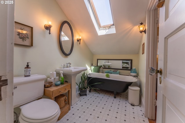 full bath with a freestanding tub, tile patterned floors, toilet, and lofted ceiling with skylight