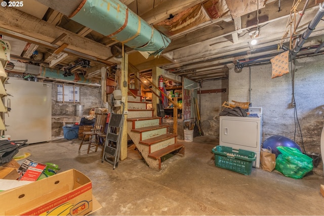 unfinished basement with freestanding refrigerator, washer / clothes dryer, and stairway
