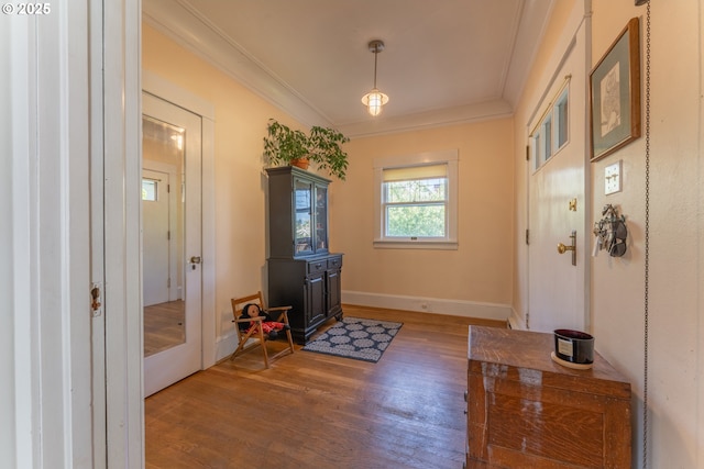 entryway featuring baseboards, ornamental molding, and wood finished floors