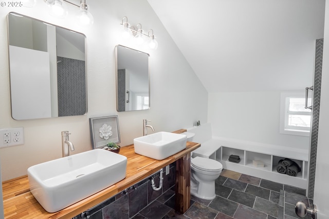28788 Gimpl Hill Rd, Eugene, OR 97402 - bathroom featuring vaulted ceiling, toilet, double vanity, and stone finish floors