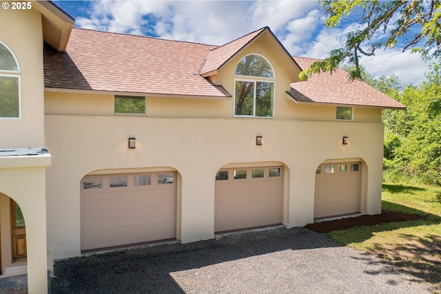 28788 Gimpl Hill Rd, Eugene, OR 97402 - view of front of house featuring stucco siding, an attached garage, gravel driveway, and a shingled roof