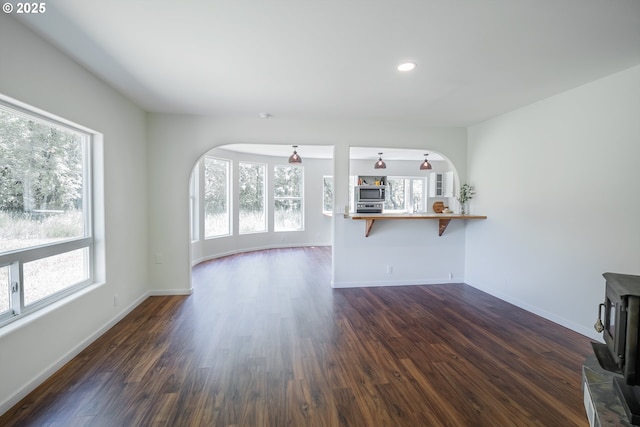 28788 Gimpl Hill Rd, Eugene, OR 97402 - unfurnished living room with healthy amount of natural light, arched walkways, a wood stove, dark wood finished floors, and recessed lighting