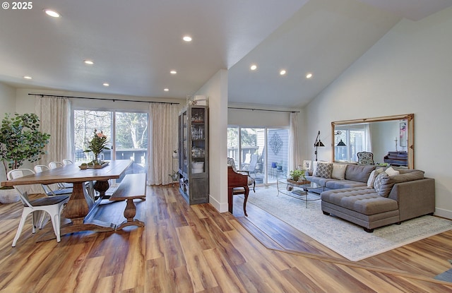 living room featuring baseboards, high vaulted ceiling, wood finished floors, and recessed lighting