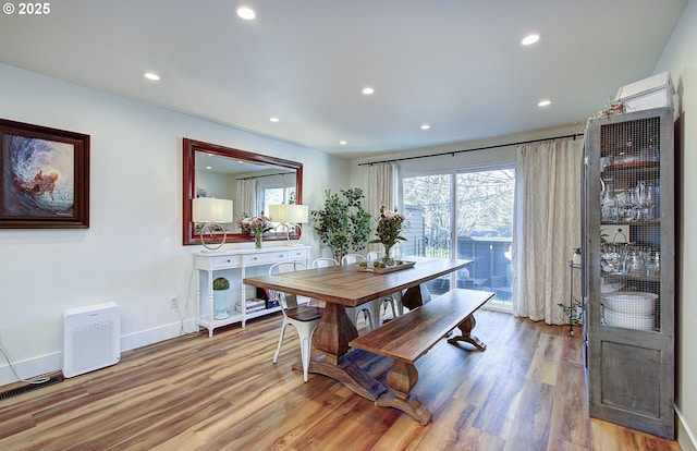 dining area featuring visible vents, baseboards, wood finished floors, and recessed lighting