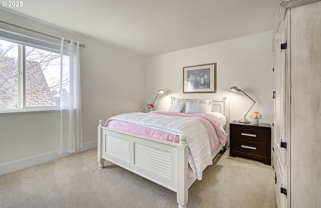 bedroom with light carpet and baseboards