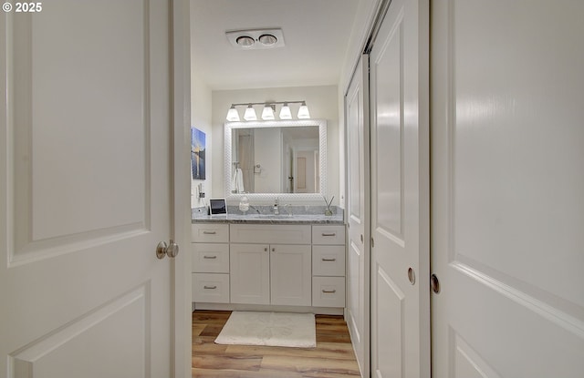 bathroom with visible vents, wood finished floors, and vanity