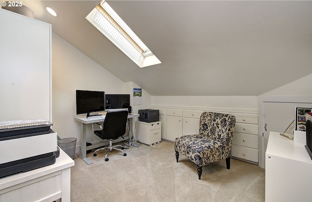 home office with vaulted ceiling with skylight and light carpet