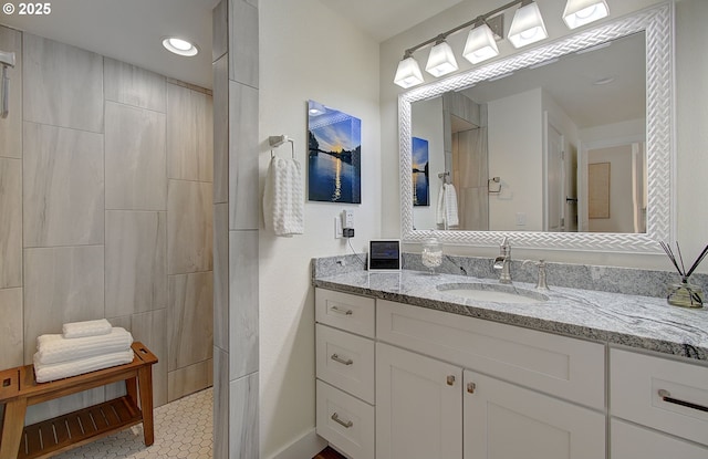 full bath with a tile shower and vanity