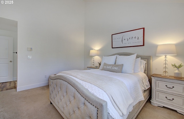 bedroom featuring light colored carpet and baseboards