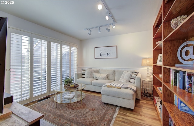 living area with visible vents and wood finished floors