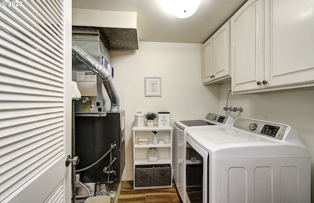 laundry area featuring cabinet space, dark wood finished floors, and washing machine and clothes dryer