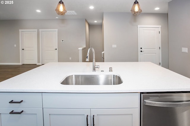 kitchen featuring dishwasher, sink, white cabinets, and decorative light fixtures