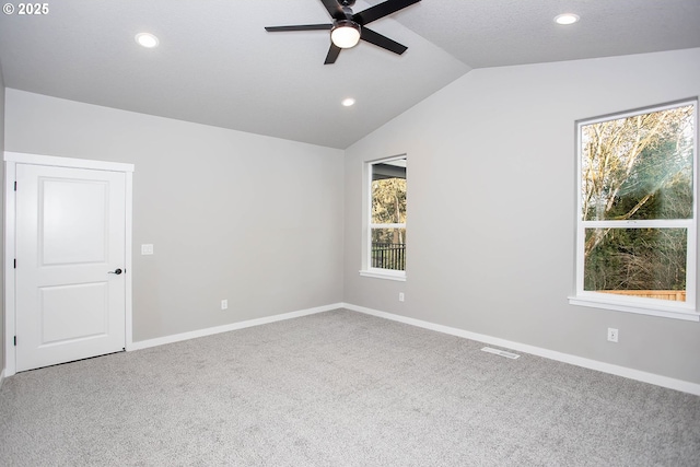 spare room featuring lofted ceiling, carpet floors, and ceiling fan