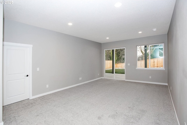 carpeted empty room featuring a textured ceiling