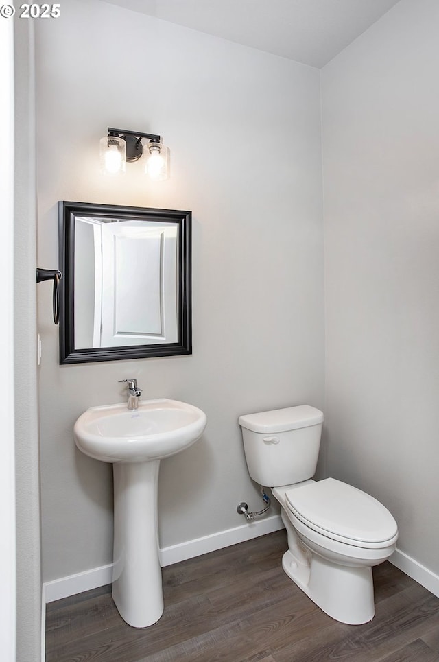 bathroom featuring wood-type flooring and toilet