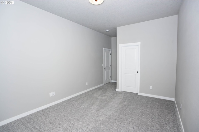 carpeted empty room featuring a textured ceiling