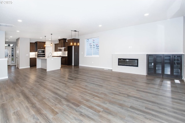 unfurnished living room with sink and dark hardwood / wood-style floors