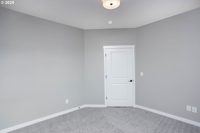 empty room with carpet floors and a textured ceiling