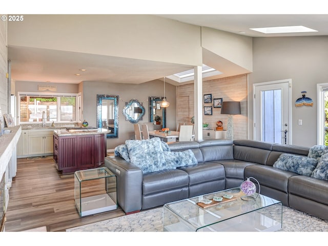 living area with recessed lighting, a skylight, and wood finished floors