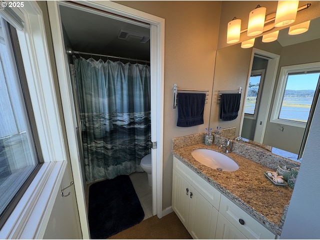 bathroom featuring vanity, curtained shower, visible vents, and toilet