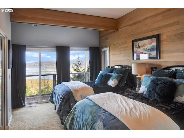 bedroom with visible vents, wood walls, beam ceiling, access to outside, and carpet flooring