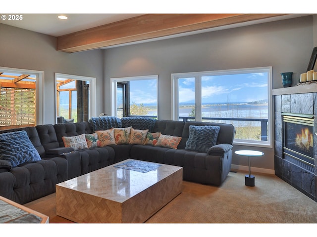 living room featuring recessed lighting, carpet flooring, a water view, and a tile fireplace