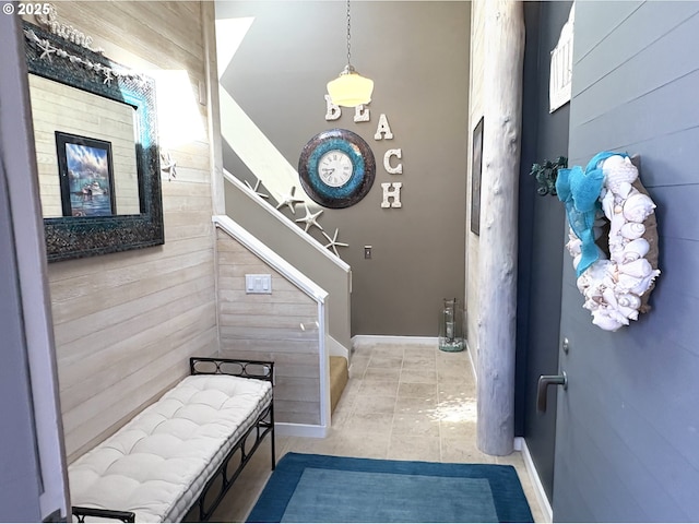 interior space with wooden walls and light tile patterned flooring