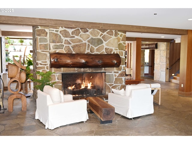 living room featuring stairs and a stone fireplace