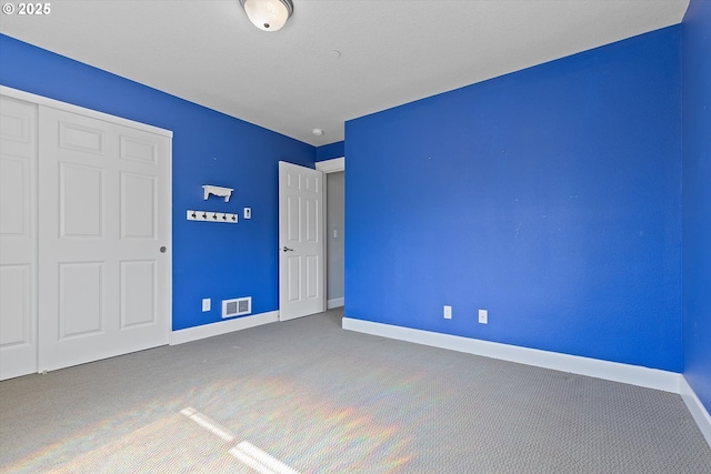 unfurnished bedroom with carpet flooring and a closet