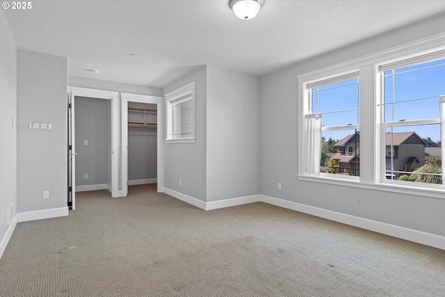 7115 NE Benton Pl, Newport, OR 97365 - unfurnished bedroom with carpet flooring, baseboards, a closet, and a textured ceiling
