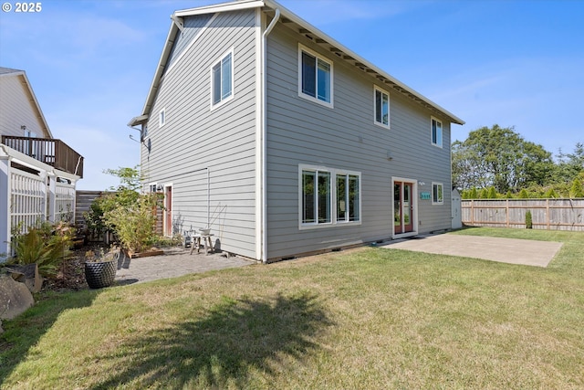 rear view of house featuring a patio area and a yard