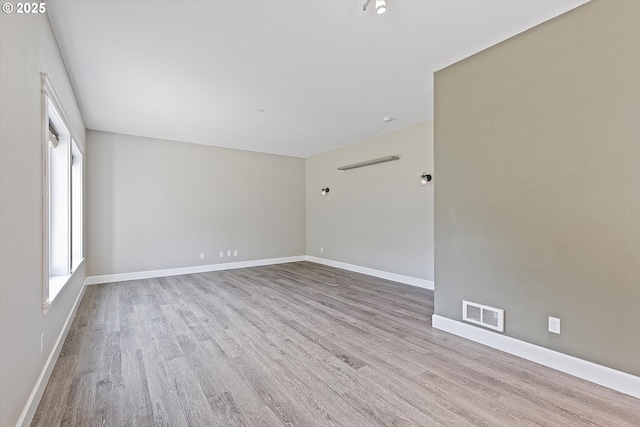 unfurnished room with plenty of natural light and light hardwood / wood-style floors