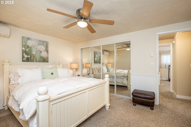 bedroom with light colored carpet, wainscoting, a wall mounted AC, and a closet