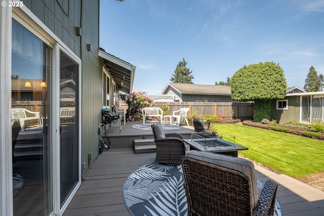 wooden terrace with a lawn and fence