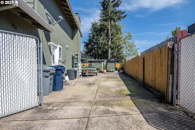 view of property exterior with a storage shed, an outbuilding, a fenced backyard, and a patio area