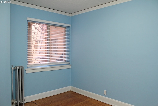 unfurnished room with radiator, crown molding, baseboards, and wood finished floors