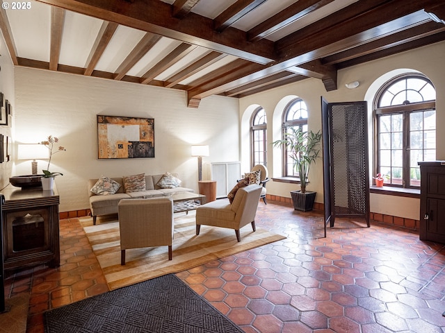 tiled living room with baseboards and beamed ceiling