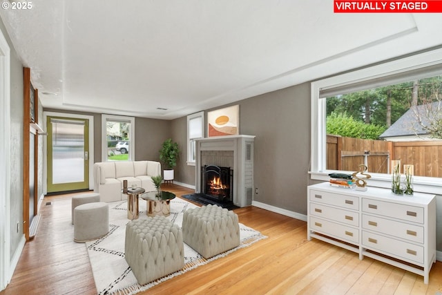 8978 SW Terreton Pl, Portland, OR 97223 - living room featuring light wood-style flooring, baseboards, and a fireplace