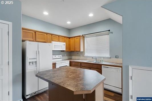 8465 S Hollyhock St, Rockaway Beach, OR 97136 - kitchen featuring dark wood-style floors, a center island, a sink, and white appliances
