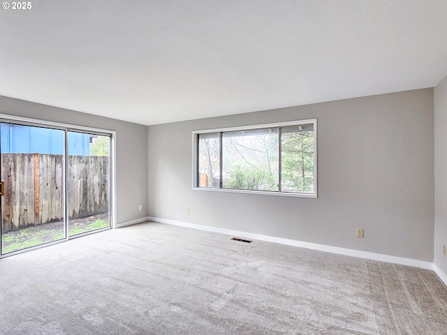 empty room with light carpet and a textured ceiling