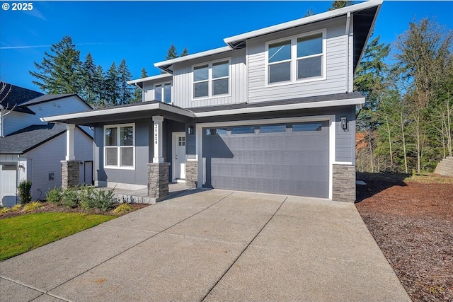 view of front facade featuring a garage, stone siding, board and batten siding, and concrete driveway