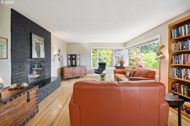 8301 SW 6th Ave, Portland, OR 97219 - living area with light wood-style floors, a fireplace, and a textured ceiling