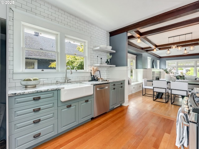 kitchen with stainless steel appliances, a sink, light wood-style flooring, decorative backsplash, and beam ceiling