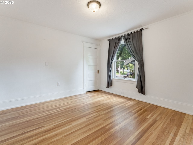 empty room featuring light wood-style floors and baseboards