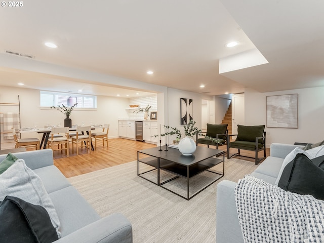 living area with light wood finished floors, recessed lighting, stairway, and wine cooler
