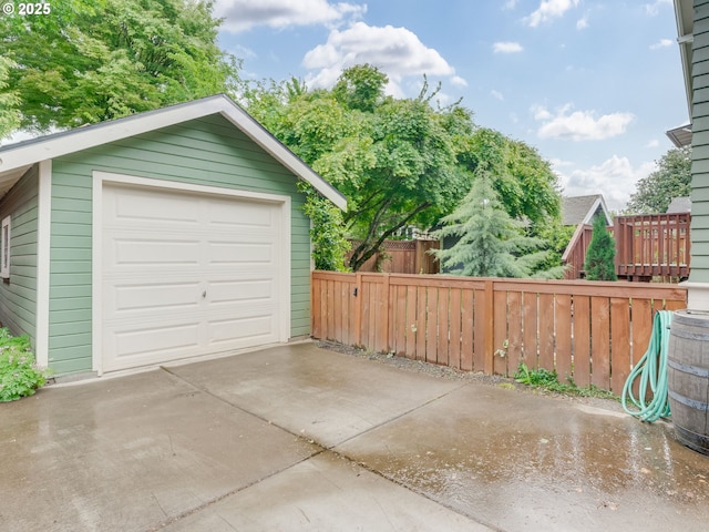 detached garage with driveway and fence