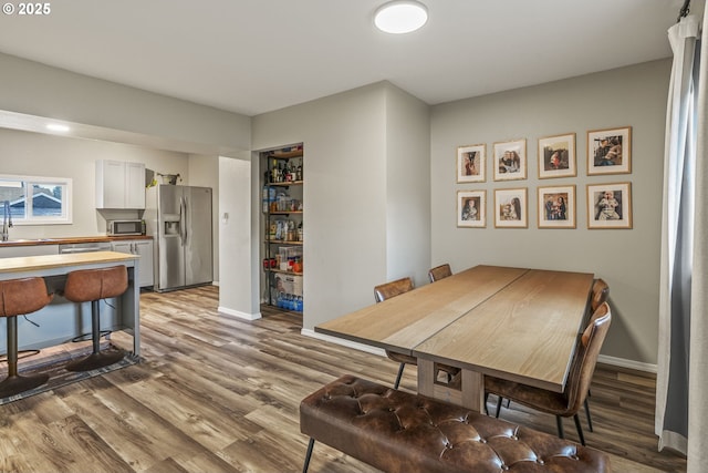 dining space featuring sink and light hardwood / wood-style floors