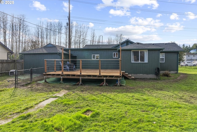 back of property with a wooden deck and a lawn