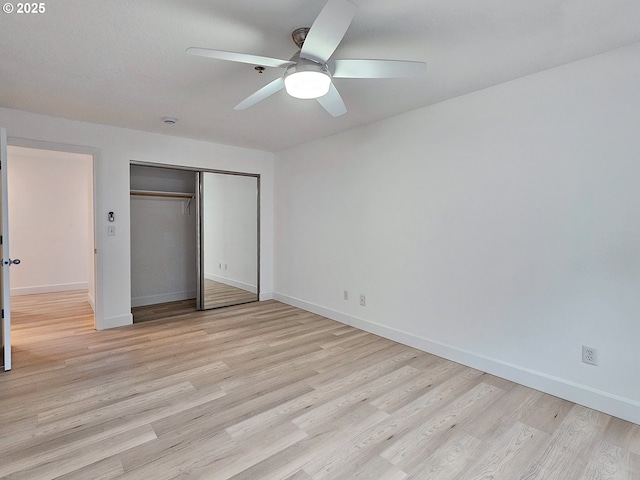 unfurnished bedroom with baseboards, ceiling fan, a closet, and light wood-style floors