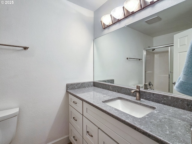 bathroom with vanity, toilet, and an enclosed shower